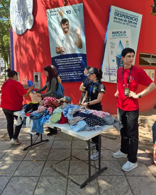 Voluntarios de Bio Gea acomodando ropa donada en una mesa de la plazuela Álvaro Obregón